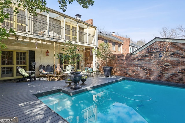 view of swimming pool with a fenced in pool and a wooden deck