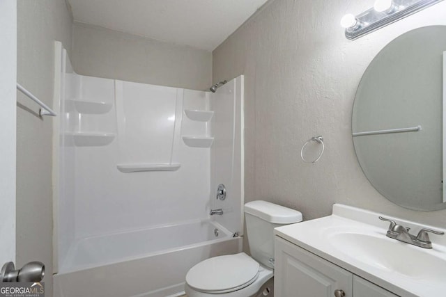 bathroom with toilet, a textured wall, tub / shower combination, and vanity