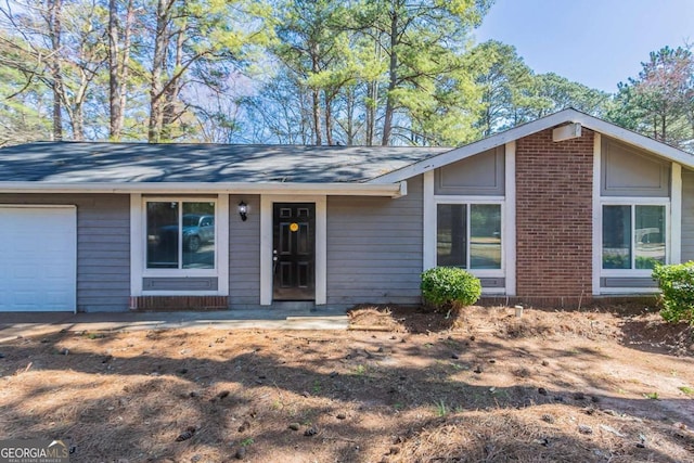 view of front of property featuring brick siding and an attached garage