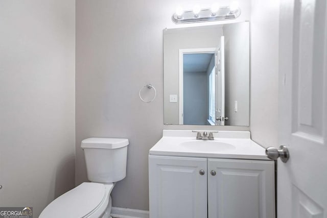 half bathroom with vanity and toilet