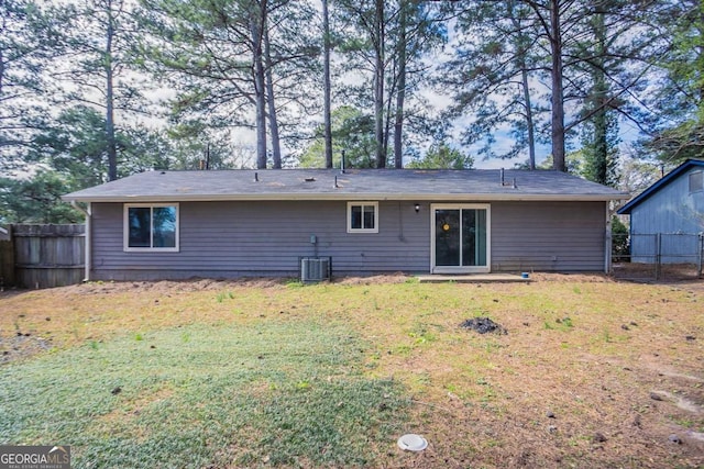 rear view of house featuring a yard and fence