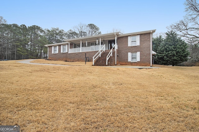 ranch-style home featuring a porch, a front yard, brick siding, and stairs