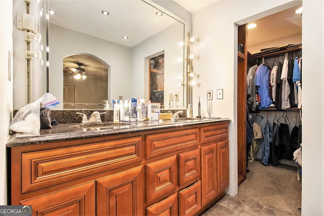 bathroom featuring ceiling fan, recessed lighting, a sink, double vanity, and a walk in closet