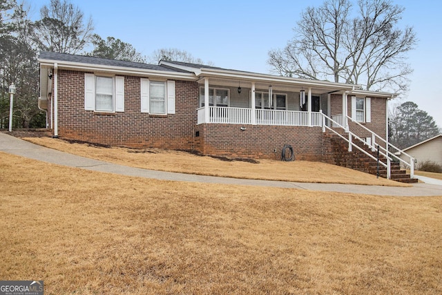 ranch-style home with a porch, stairs, a front lawn, and brick siding