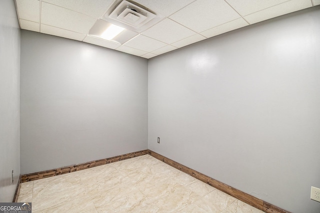 unfurnished room featuring a drop ceiling, visible vents, and baseboards