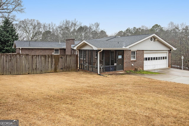 view of front facade featuring driveway, a sunroom, fence, a front lawn, and brick siding