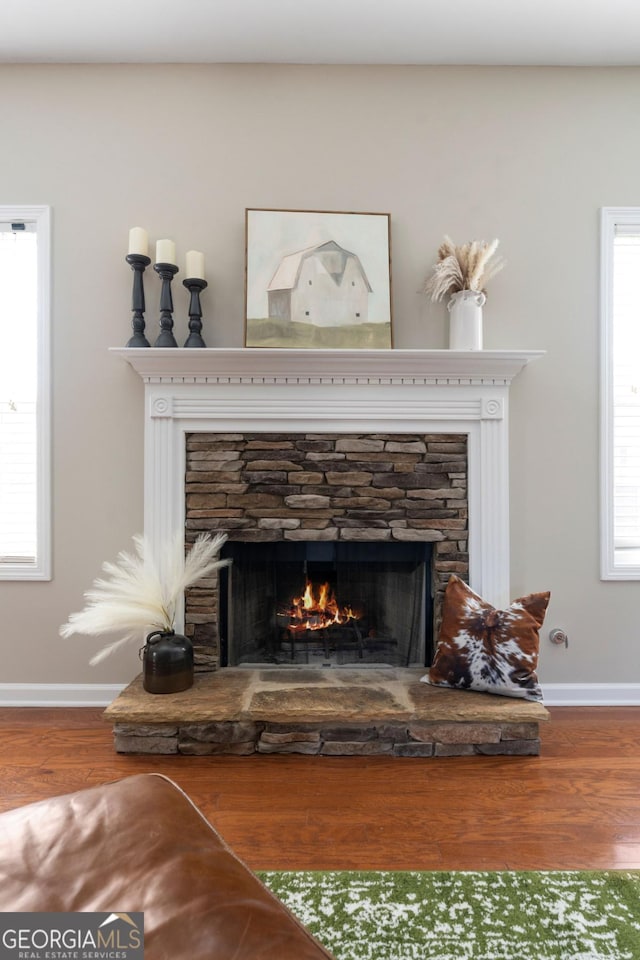 details with a fireplace, baseboards, and wood finished floors