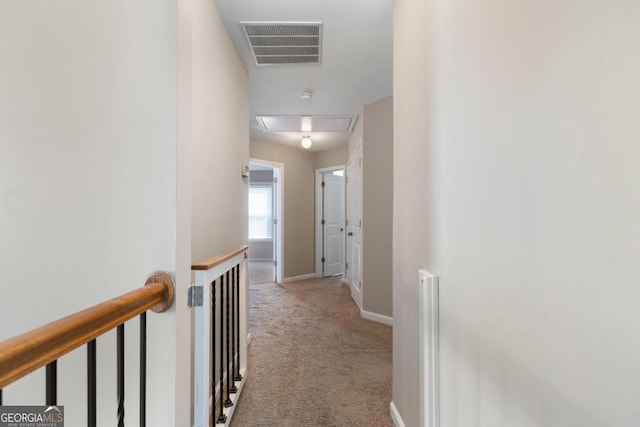 hall with light colored carpet, an upstairs landing, baseboards, visible vents, and attic access