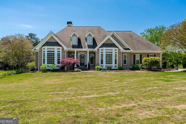 view of front of home with a front yard, brick siding, and a chimney