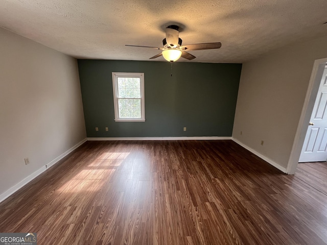 unfurnished room with dark wood-style floors, a textured ceiling, baseboards, and a ceiling fan