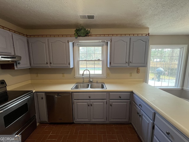 kitchen featuring visible vents, stainless steel appliances, a sink, and light countertops