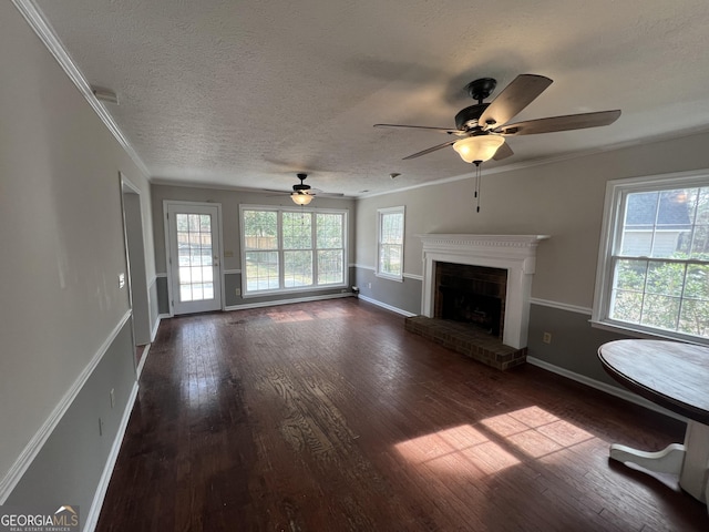 unfurnished living room featuring a fireplace, dark wood finished floors, and crown molding