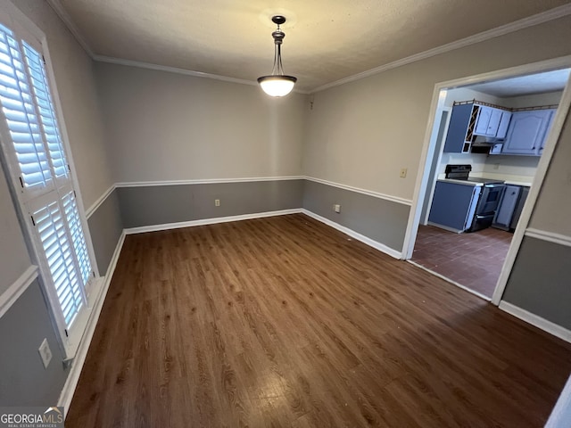 unfurnished dining area with dark wood-type flooring, ornamental molding, and baseboards