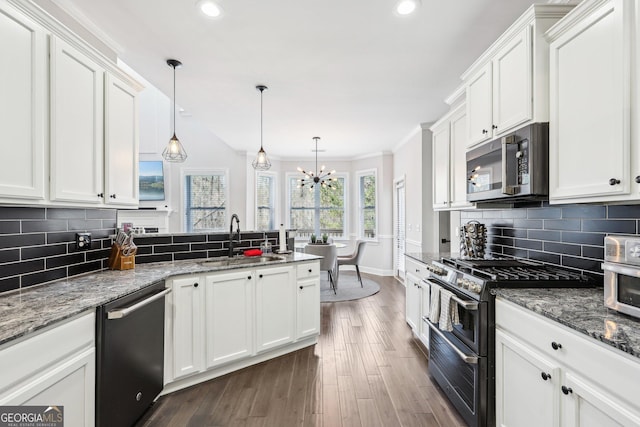 kitchen featuring a sink, a peninsula, appliances with stainless steel finishes, and white cabinets