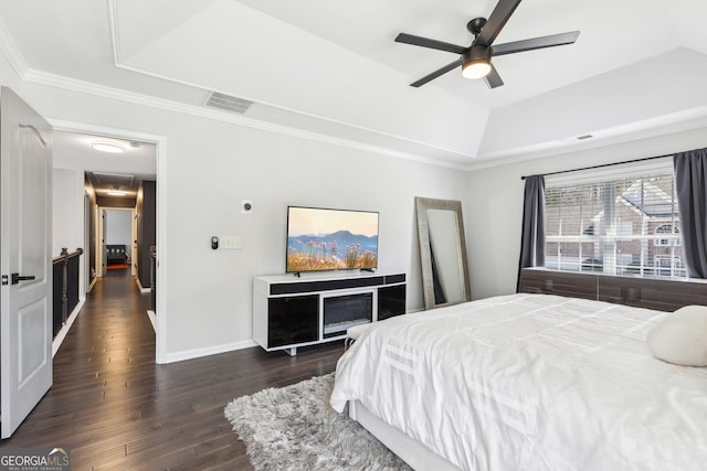 bedroom featuring baseboards, visible vents, dark wood finished floors, a tray ceiling, and ornamental molding