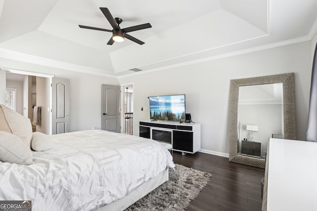 bedroom with dark wood finished floors, a raised ceiling, baseboards, and visible vents