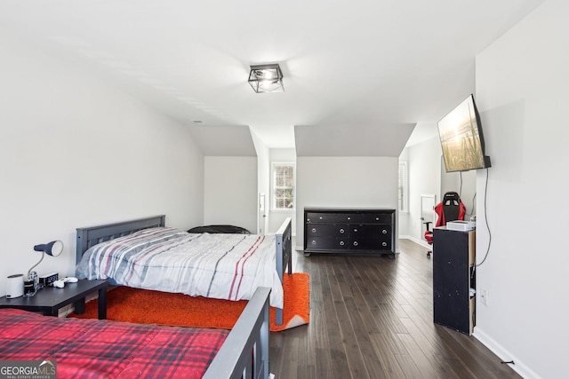 bedroom with dark wood-type flooring and baseboards