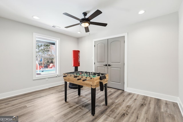 game room with light wood-type flooring, visible vents, and baseboards