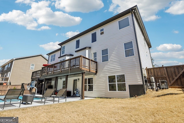 rear view of house with a yard, fence, a fenced in pool, and a patio area