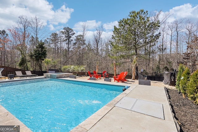 view of pool featuring a patio, a fenced backyard, and a pool with connected hot tub