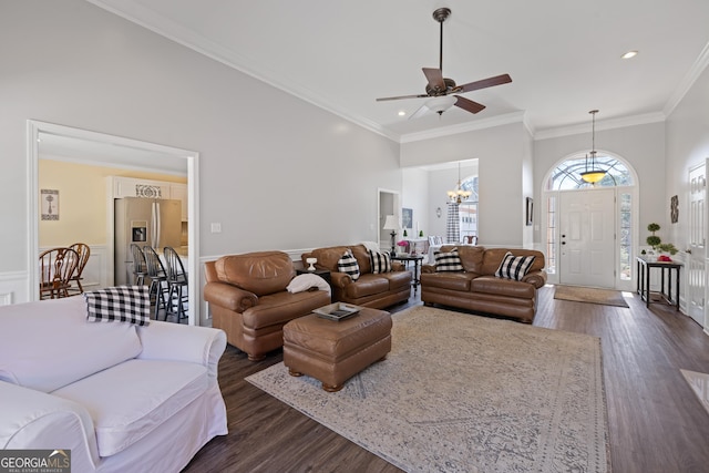 living room with ornamental molding, dark wood finished floors, a towering ceiling, and recessed lighting