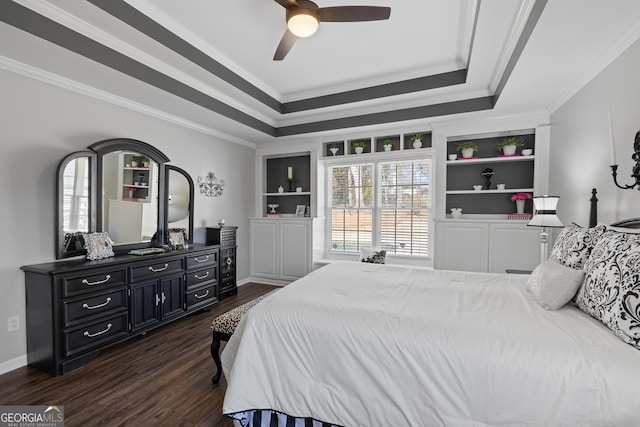 bedroom featuring ornamental molding, dark wood-type flooring, a raised ceiling, and baseboards