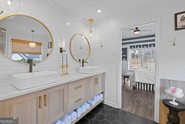 bathroom with connected bathroom, crown molding, a sink, and double vanity