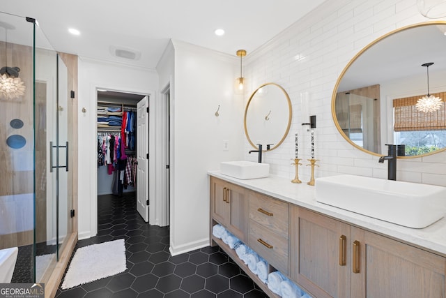 bathroom with a shower stall, decorative backsplash, a sink, and crown molding