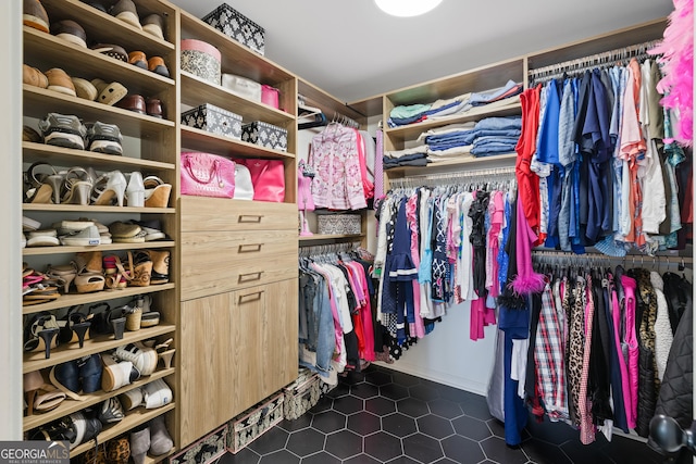 walk in closet with dark tile patterned flooring