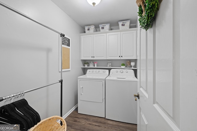 clothes washing area with dark wood-style flooring, washing machine and dryer, and cabinet space