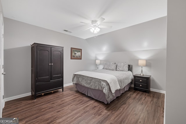 bedroom with baseboards, visible vents, vaulted ceiling, and dark wood-style flooring