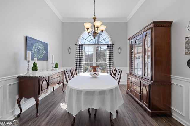 dining area with a decorative wall, a wainscoted wall, a notable chandelier, dark wood-style floors, and crown molding