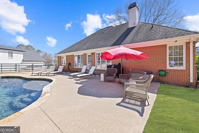 view of swimming pool featuring a patio, a yard, and fence