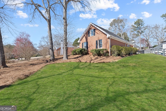 view of home's exterior with fence and a yard