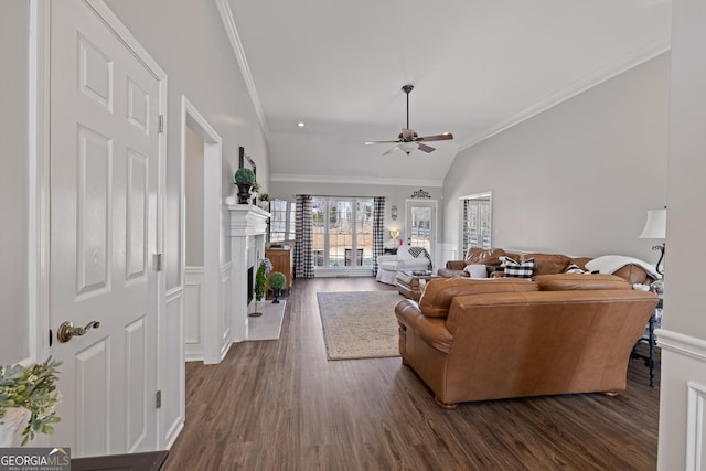 living room with dark wood finished floors, a fireplace, crown molding, lofted ceiling, and a ceiling fan