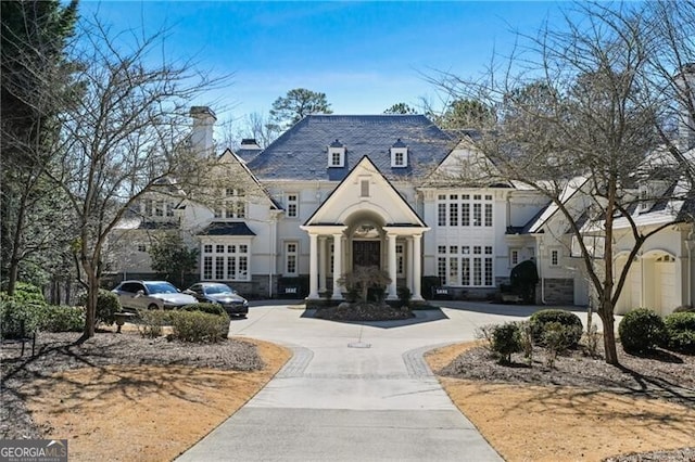 french provincial home featuring concrete driveway