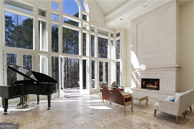 sunroom featuring lofted ceiling, french doors, and a high end fireplace