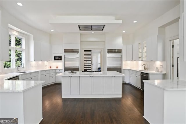 kitchen featuring stainless steel built in fridge, white cabinetry, a sink, and dishwasher