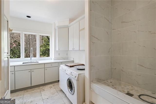 laundry area with laundry area, a sink, and separate washer and dryer