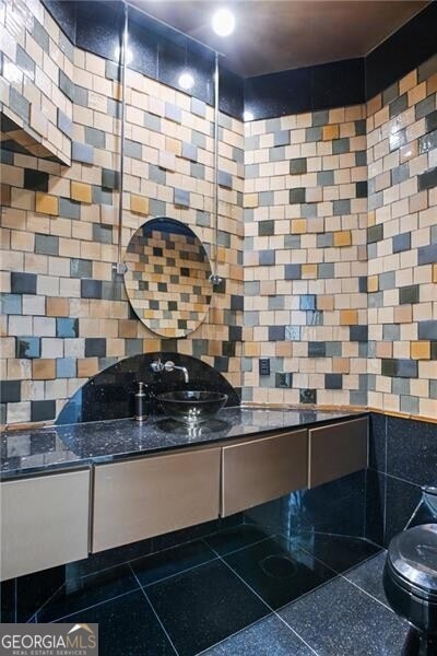 bathroom featuring vanity, toilet, and tile walls