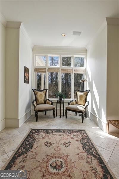 sitting room featuring baseboards and crown molding