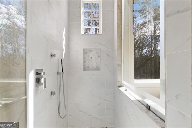 full bathroom featuring a marble finish shower