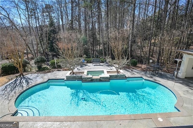 view of pool with a pool with connected hot tub and a patio