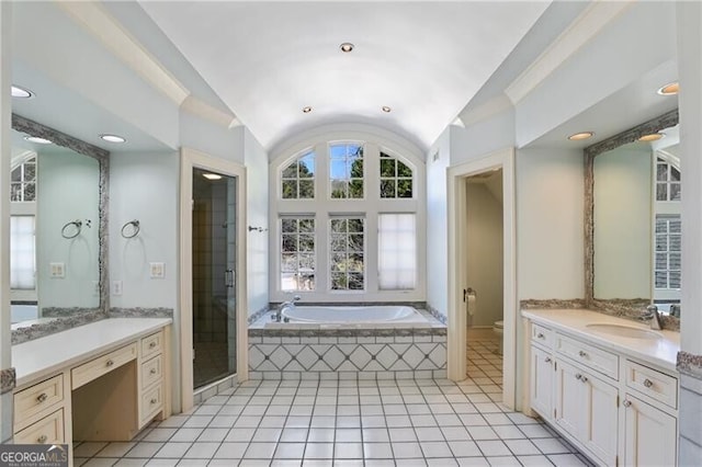 bathroom with lofted ceiling, toilet, a garden tub, a shower stall, and a sink