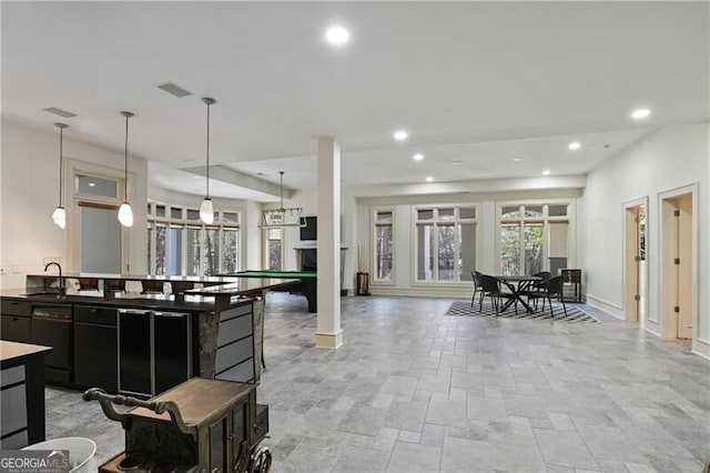 kitchen with open floor plan, dark cabinetry, a sink, and recessed lighting