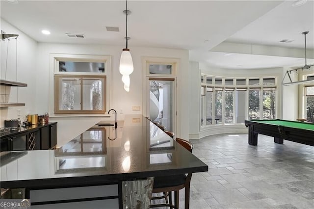 interior space featuring visible vents, pool table, stone tile flooring, and pendant lighting