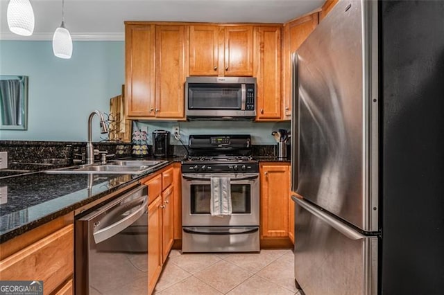 kitchen with stainless steel appliances, hanging light fixtures, a sink, and brown cabinets