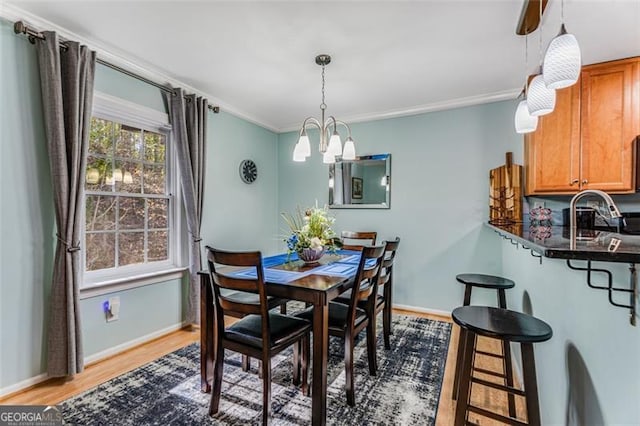 dining room with crown molding, wood finished floors, and baseboards