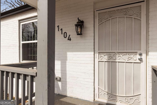 doorway to property featuring brick siding