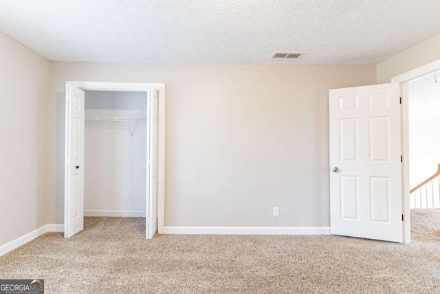 unfurnished bedroom with light carpet, visible vents, and baseboards